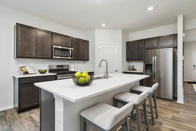 9968 Central Park Blvd, Huntley, IL 60142 - kitchen with appliances with stainless steel finishes, dark brown cabinets, a kitchen breakfast bar, light wood-style floors, and recessed lighting