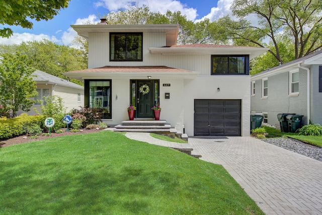 627 Beaver Rd, Glenview, IL 60025 - view of front of home with a chimney, a garage, brick siding, decorative driveway, and a front lawn