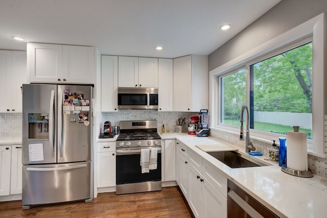 627 Beaver Rd, Glenview, IL 60025 - kitchen featuring a sink, backsplash, white cabinets, and stainless steel appliances