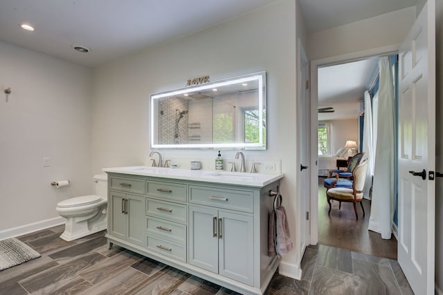 627 Beaver Rd, Glenview, IL 60025 - bathroom featuring double vanity, toilet, a tile shower, and a sink