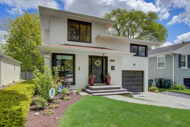 627 Beaver Rd, Glenview, IL 60025 - contemporary home featuring concrete driveway, brick siding, a front yard, and a garage