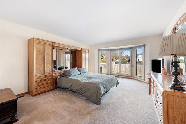 bedroom featuring visible vents, light colored carpet, and baseboards