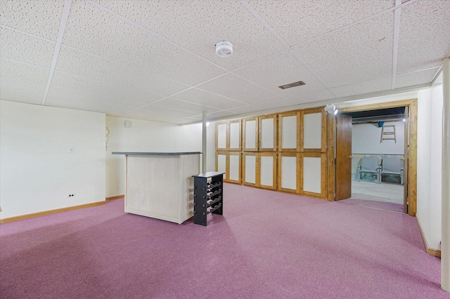 finished below grade area featuring baseboards, visible vents, carpet, and a paneled ceiling