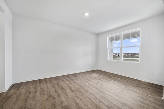 spare room with wood finished floors and baseboards