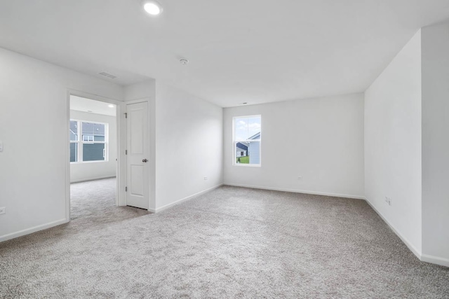 carpeted spare room featuring recessed lighting, visible vents, a wealth of natural light, and baseboards