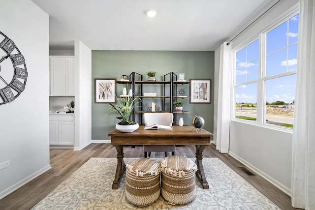 office with wood finished floors, visible vents, and baseboards