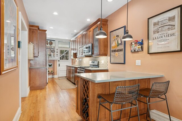 725 Erie St Unit 1D, Oak Park, IL 60302 - kitchen featuring stainless steel appliances, light wood-style floors, brown cabinets, backsplash, and recessed lighting
