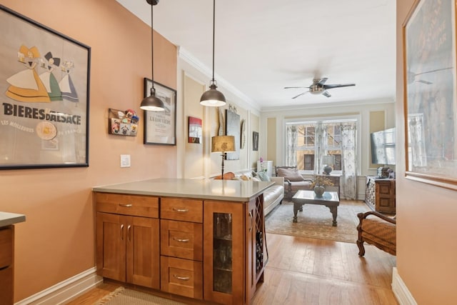 725 Erie St Unit 1D, Oak Park, IL 60302 - kitchen featuring brown cabinetry, light wood finished floors, ornamental molding, ceiling fan, and a peninsula