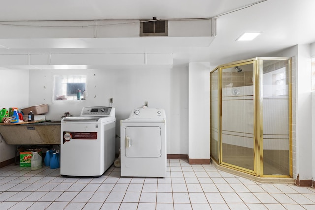 clothes washing area with washing machine and clothes dryer, light tile patterned floors, laundry area, visible vents, and baseboards