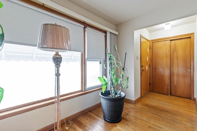 corridor featuring baseboards and light wood-style flooring