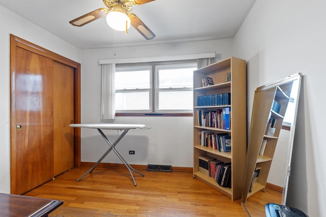 misc room with a ceiling fan, visible vents, baseboards, and light wood-type flooring