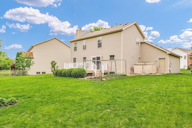 4603 Stonebridge Dr, Champaign, IL 61822 - rear view of house with fence, a wooden deck, a chimney, and a lawn
