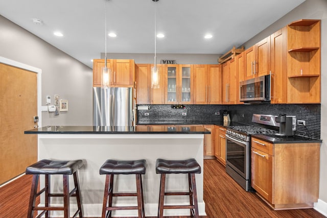 2112 W Belmont Ave Unit 1, Chicago, IL 60618 - kitchen featuring open shelves, appliances with stainless steel finishes, dark wood-type flooring, and a kitchen bar