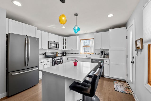 kitchen featuring backsplash, white cabinetry, appliances with stainless steel finishes, and a sink
