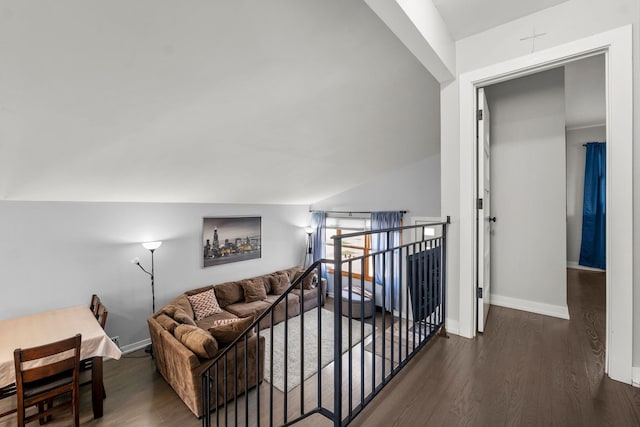 hall featuring baseboards, wood finished floors, and an upstairs landing