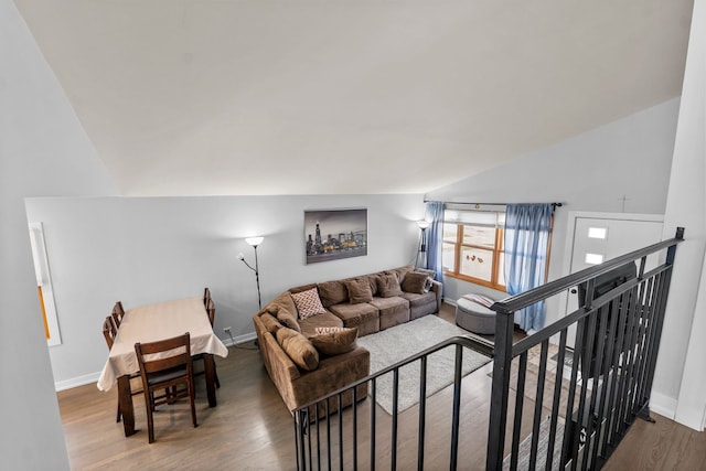 living area with baseboards, wood finished floors, and lofted ceiling