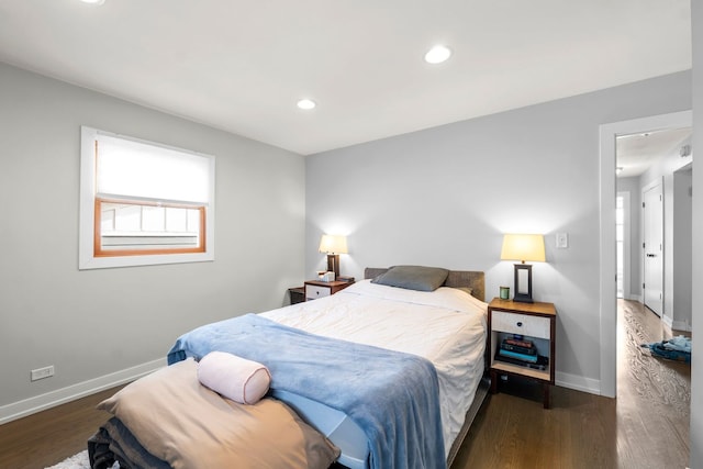 bedroom featuring baseboards, multiple windows, and wood finished floors