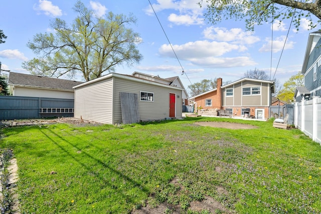 view of yard featuring an outdoor structure, a patio, and a fenced backyard