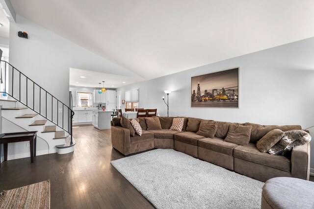 living room featuring dark wood-type flooring, recessed lighting, lofted ceiling, and stairway
