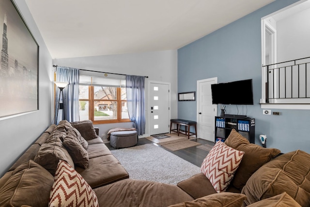 living area with wood finished floors and high vaulted ceiling