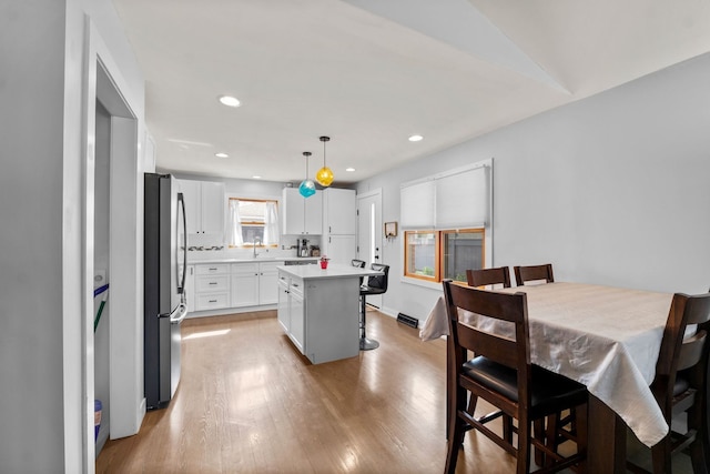 dining room with recessed lighting and light wood-style flooring