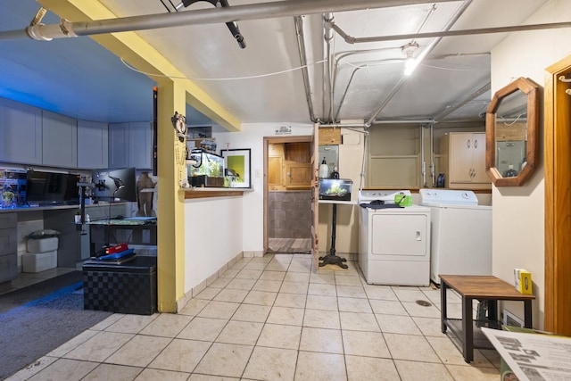 washroom featuring light tile patterned floors, separate washer and dryer, laundry area, and baseboards