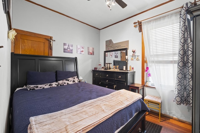 bedroom with wood finished floors, crown molding, and a ceiling fan