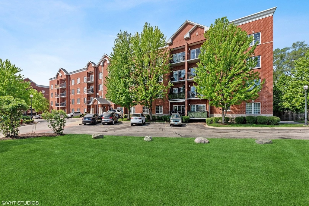 view of apartment building / complex with uncovered parking