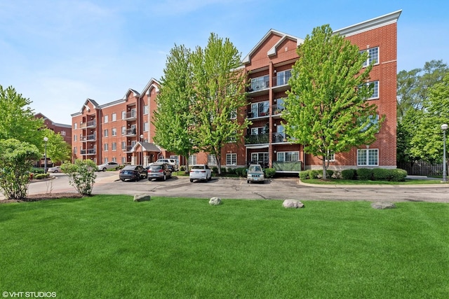 view of apartment building / complex with uncovered parking