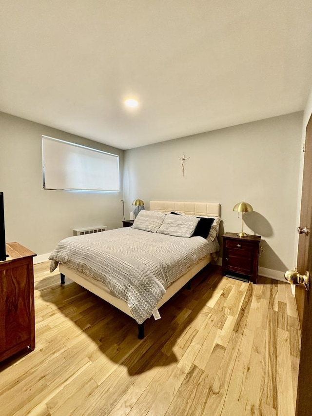 bedroom with wood finished floors and baseboards
