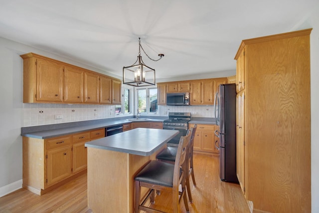 1075 Grand Mesa Ave, New Lenox, IL 60451 - kitchen featuring decorative backsplash, a center island, a sink, light wood-style flooring, and appliances with stainless steel finishes
