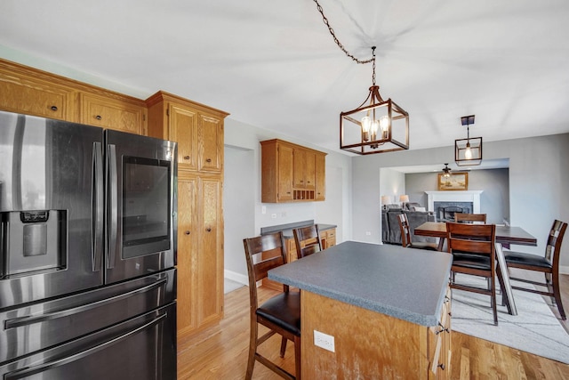 1075 Grand Mesa Ave, New Lenox, IL 60451 - kitchen with an inviting chandelier, light wood finished floors, a fireplace, stainless steel fridge with ice dispenser, and a center island