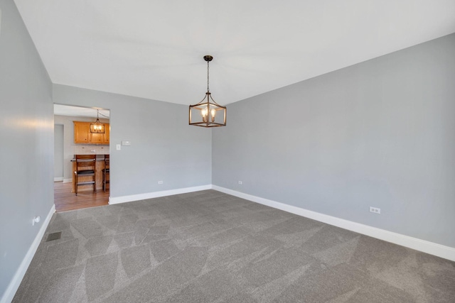 1075 Grand Mesa Ave, New Lenox, IL 60451 - spare room with visible vents, baseboards, dark carpet, and a chandelier