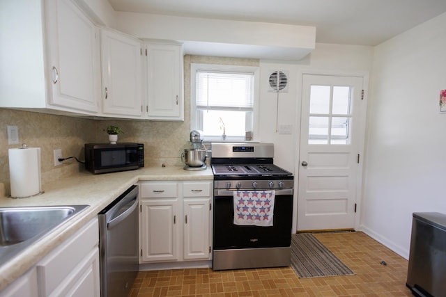 518 N Hartwell St, Gilman, IL 60938 - kitchen with white cabinets, appliances with stainless steel finishes, a wealth of natural light, and tasteful backsplash
