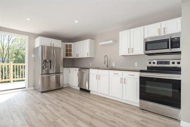 510 E Washington St, Pontiac, IL 61764 - kitchen with dark countertops, a sink, appliances with stainless steel finishes, and light wood-style floors