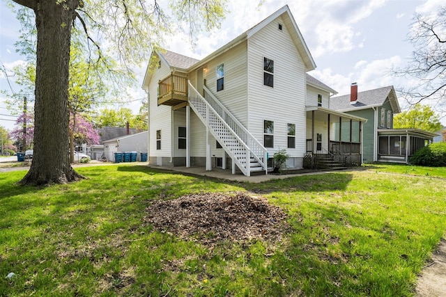 510 E Washington St, Pontiac, IL 61764 - rear view of property featuring stairway, a sunroom, and a lawn