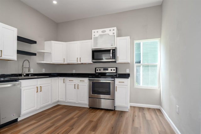 510 E Washington St, Pontiac, IL 61764 - kitchen with light wood finished floors, a sink, open shelves, white cabinetry, and appliances with stainless steel finishes