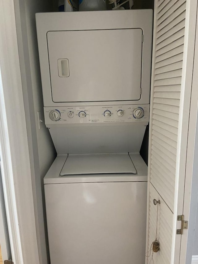 washroom with stacked washer and clothes dryer and laundry area