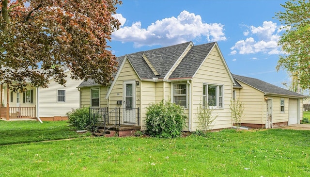 rear view of property with a yard and roof with shingles
