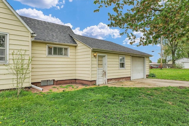 view of side of property featuring a shingled roof, driveway, and a lawn