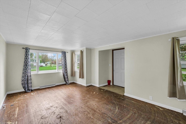 empty room with a baseboard radiator, crown molding, wood finished floors, and baseboards