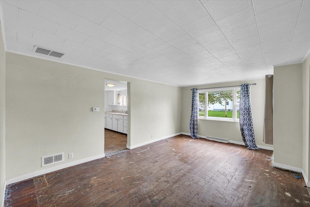 unfurnished room with baseboards, a baseboard radiator, wood-type flooring, and visible vents