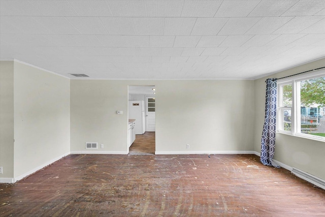 unfurnished room with baseboards, ornamental molding, wood-type flooring, and visible vents