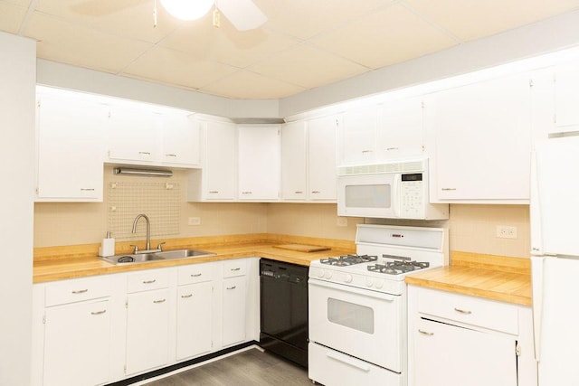 kitchen featuring a paneled ceiling, a sink, decorative backsplash, white cabinetry, and white appliances