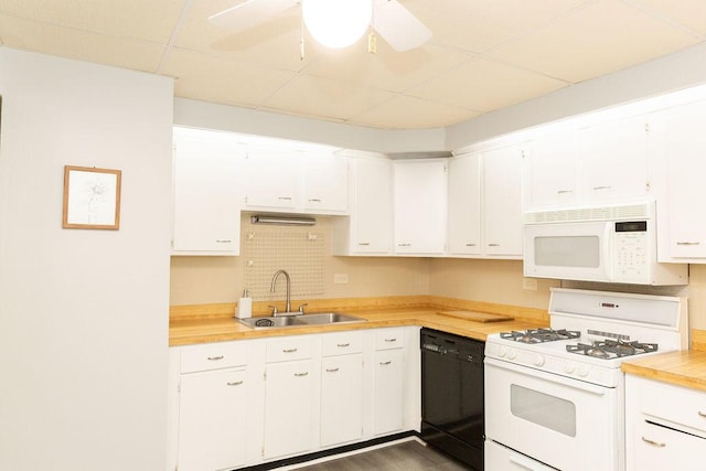 kitchen with light countertops, a sink, white cabinets, and white appliances