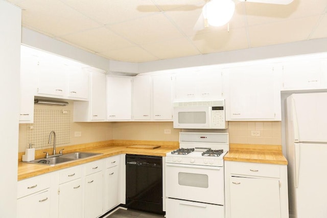 kitchen with tasteful backsplash, white appliances, a sink, white cabinetry, and a paneled ceiling