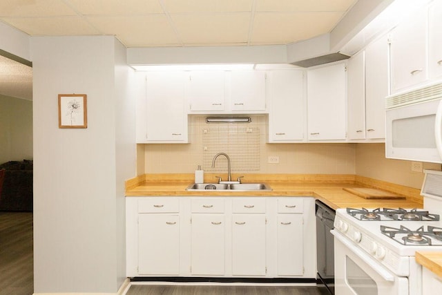 kitchen with white cabinets, white appliances, light countertops, and a sink