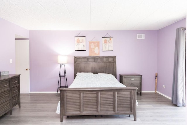 bedroom featuring visible vents, wood finished floors, and baseboards