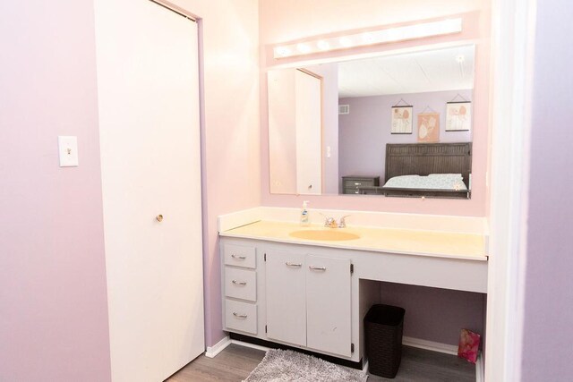 bathroom with vanity, visible vents, and wood finished floors