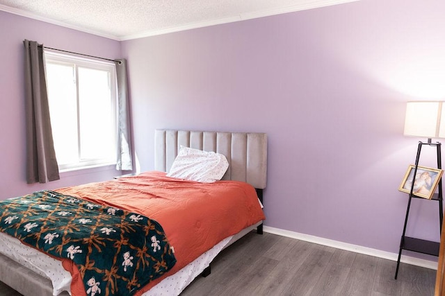 bedroom with baseboards, wood finished floors, and crown molding